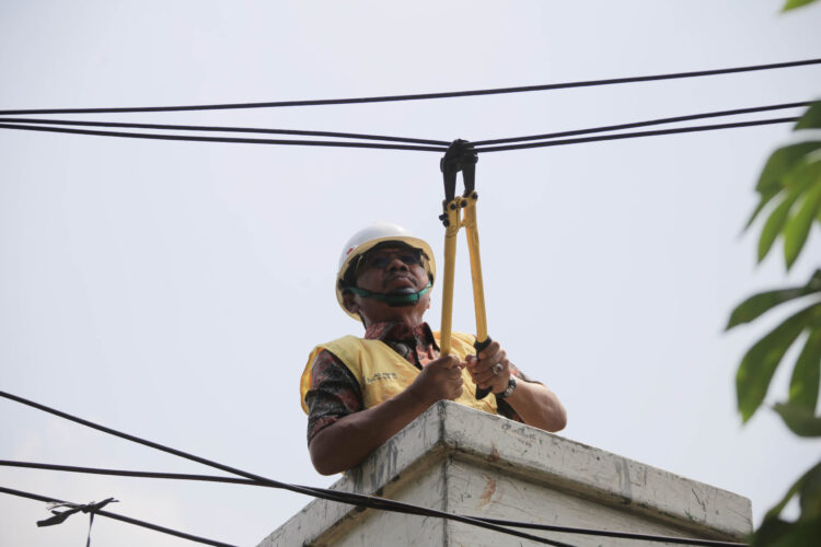 petugas tengah melakukan penertiban kabel udara