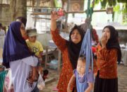 petugas menimbang berat badan balita